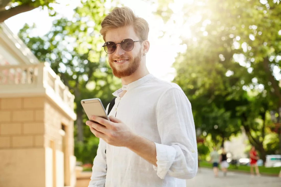 A young man checking his professional profile on his phone